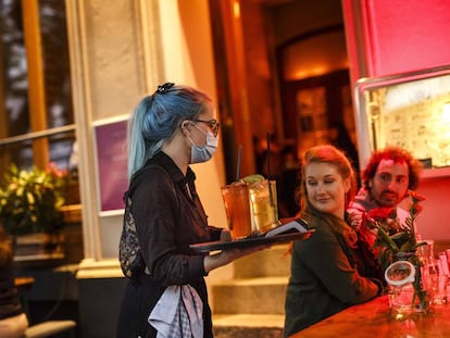 Stephanie Llynch sirve un cocktail a unos clientes cuando los bares de Berlín acaban de abrir de nuevo al público tras la crisis de Coronavirus.