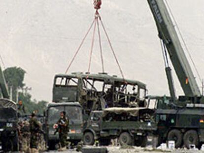 Una grúa iza el camión de la ISAF atacado ayer en Kabul.