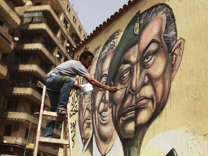 Un hombre pinta un mural en El Cairo combinando los rostros de Mubarak y Tantawi.