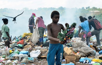 Gabriel, de 12 anos, segura a árvore de Natal que encontrou enquanto buscava comida no lixão da Piçarreira, em Pinheiro (MA).