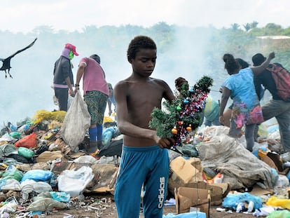 Gabriel, de 12 anos, segura a árvore de Natal que encontrou enquanto buscava comida no lixão da Piçarreira, em Pinheiro (MA).