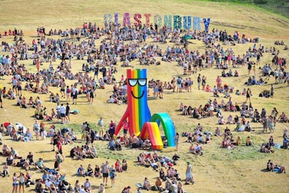Asistentes al festival de Glastonbury de 2019 en torno a una escultura del artista Paul Insect.