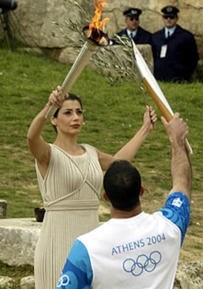 Un atleta enciende la antorcha de Atenas 2004 en Olimpia.