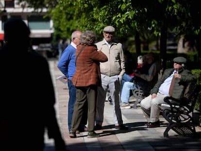 A group of older people talking in a park in Seville, Spain.
