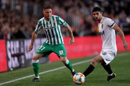 El centrocampista portugués del Valencia, Gonçalo Guedes, disputa un balón con el mediapunta del Real Betis, Joaquín, en una acción del partido.