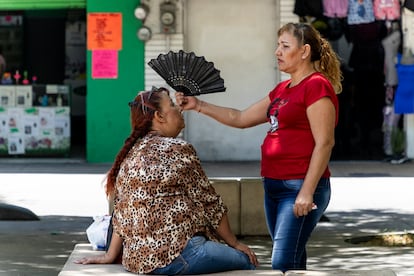 Personas se abanican en el Paseo Alcalde, de Guadalajara, Jalisco, debido a las altas temperaturas.