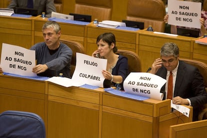 Diputados del BNG muestran carteles contra el "saqueo" de la caja, en el pleno de anteayer.