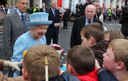 La reina Isabel II habla con niños antes de asistir a un servicio religioso en Enniskillen, Irlanda del Norte.