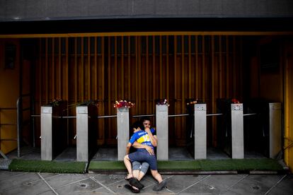 El barrio La Boca, al sur de la ciudad de Buenos Aires, fue la segunda patria de Diego Maradona. En la foto, tomada el 25 de noviembre de 2020, una madre y su hijo se abrazan frente a los molinetes de ingresos de La Bombonera, el estadio de Boca Juniors. Se han enterado hace minutos de la muerte del ídolo.