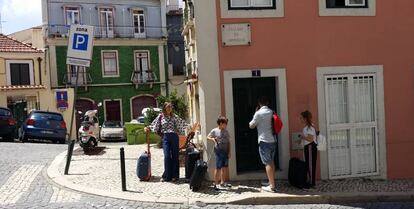 Turistas esperan la entrada en en piso del barrio de Alcántara.