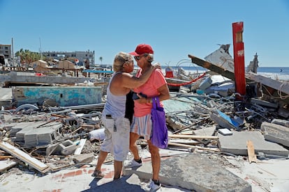 Two women who have lost their businesses embrace after Hurricane Ian passes through the island of Fort Myers Beach, Florida, on September 30, 2022.