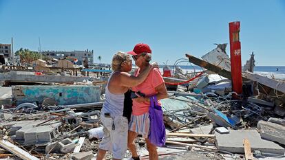 Dos mujeres que han perdido sus negocios se abrazan tras el paso del huracán Ian por la isla de Fort Myers Beach, en Florida, el 30 de septiembre de 2022.
