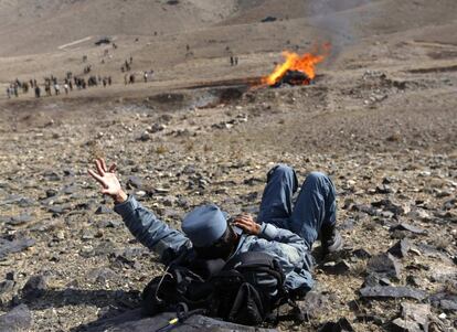 Un policía afgano habla por teléfono durante la quema de estupefacientes ilegales incautados por las fuerzas de seguridad, en Kabul, Afganistán.