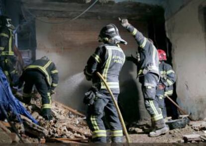 Varios bomberos colaboran en las tareas de búsqueda de dos obreros desaparecidos.
