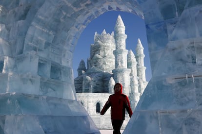 Un visitante camina a través de una escultura de hielo en el Festival de Hielo y Nieve de Harbin en China, el 7 de enero de 2019. En su edición número 35, la instalación cubre más de 600.000 metros cuadrados y cuenta con 30 áreas interactivas.