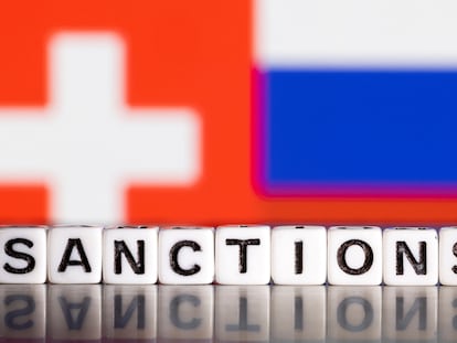 Letras que forman la palabra "sanciones", con una bandera suiza y la rusa al fondo.