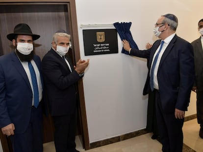 El ministro israelí de Exteriores, Yair Lapid, aplaude ante la placa que marca la inauguración de la Embajada de su país en Emiratos Árabes.