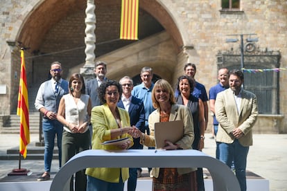 Marta Rovira, secretaria general de ERC, y Lluïsa Moret, número dos del PSC, firman el acuerdo de investidura junto a los equipos negociadores.