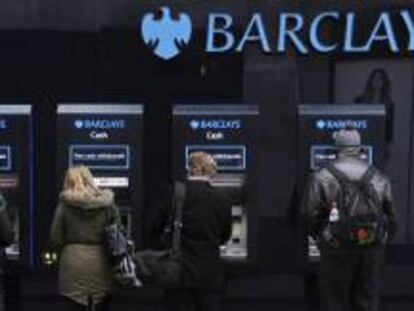 Varios clientes utilizan cajeros automáticos de una sucursal del banco británico Barclays en Londres.