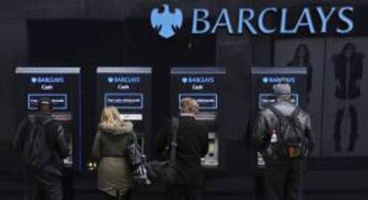 Varios clientes utilizan cajeros automáticos de una sucursal del banco británico Barclays en Londres.