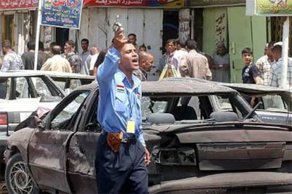 Un policía iraquí dispara al aire después de un atentado con bomba contra un convoy militar estadounidense en Bagdad.
