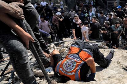Un miembro de la Defensa Civil Palestina mete la cabeza en el agujero de un edificio derrumbado durante los trabajos de búsqueda de supervivientes en Jan Yunis, este miércoles.  
