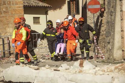 Los servicios de emergencia llevan a una mujer en silla de ruedas, en la localidad de Norcia, tras el temblor que ha sacudido la región central de Italia.