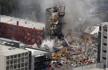 Trabajadores de los servicios de emergencia trabajan entre los escombros de un edificio derrumbado en la ciudad de Christchurch, la más afectada por el terremoto que ha dejado 65 muertos en Nueva Zelanda. Se teme que haya muchas personas atrapadas en edificios como este.