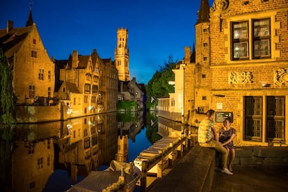 Una pareja disfruta del anochecer de Brujas en el centro histórico de la ciudad.