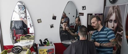 Un barbero afeita a un joven en una peluquer&iacute;a de Atenas el pasado viernes. 