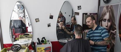 Un barber afaita un jove en una perruqueria d'Atenes divendres passat.