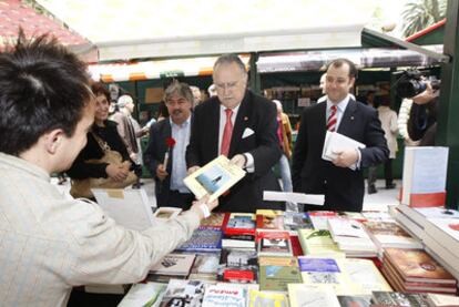 El alcalde de Bilbao, Iñaki Azkuna, compra un libro en un puesto de la feria de la capital vizcaína.