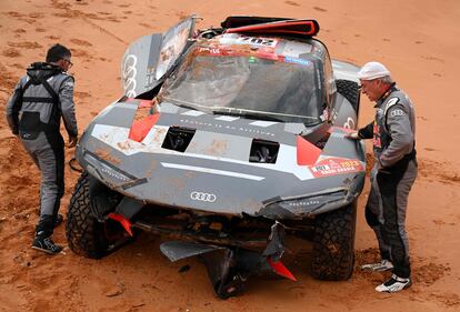 Carlos Sainz, y su copiloto, Lucas Cruz, inspeccionan su vehículo después de un accidente sufrido durante la etapa de hoy.