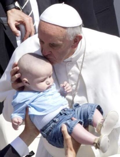 Pope Francis kisses a child at the end of the Canonization Mass in Vatican City on Sunday.