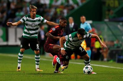 El jugador del Sporting Marcos Acuna cae ante el jugador del Barcelona Nelson Semedo en una acción del encuentro.
