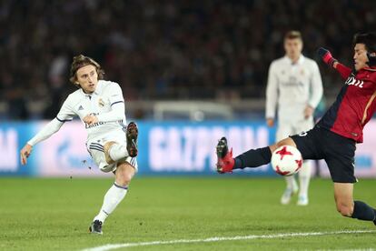 El centrocampista del Real Madrid Luka Modric (izquierda) lanza un gol bloqueado por Shuto Yamamoto del Kashima Antlers.