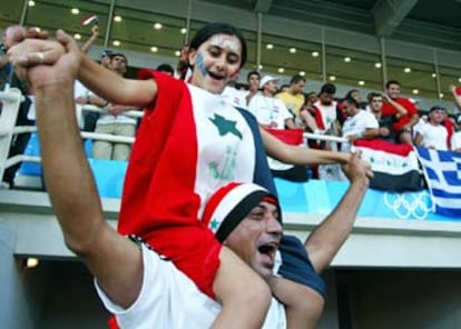 Dos hinchas iraquíes animan a sus futbolistas, que perdieron ayer su semifinal ante Paraguay.