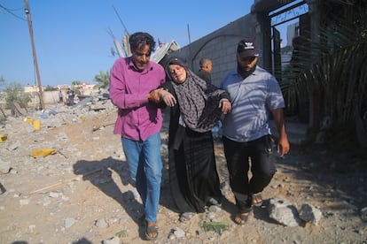 Dos hombres evacúan a una mujer herida tras un ataque israelí en Rafah, en la franja de Gaza, este viernes.