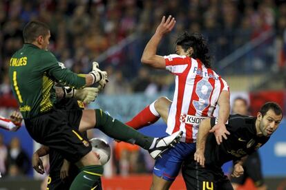 Falcao intenta rematar entre Victor Valdés y Mascherano durante el partido correpondiente a la 25ª jornada de Liga de Primera División, entre el Atlético de Madrid y el Barcelona, en el estadio Vicente Calderón. (26/02/2012).