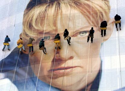 Varios trabajadores dan los toques finales a una fotografía gigante de una atleta olímpica en el edificio de oficinas de las instalaciones de los Juegos de Salt Lake City 2002.