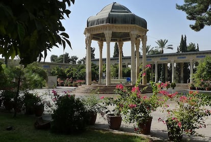 Interior de la tumba de Hafez, adornada con plantas y macetas.