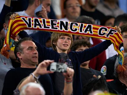 Aficionado del Valencia sostiene una bufanda de su equipo.