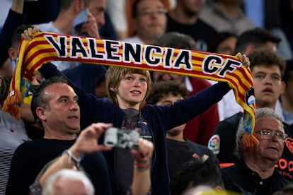 Aficionado del Valencia sostiene una bufanda de su equipo.