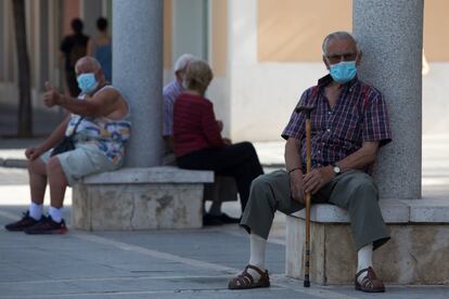 Un grupo de ancianos se resguarda del sol en una calle de Aranjuez (Madrid).