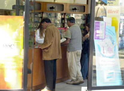 Varios ciudadanos compran medicinas en una farmacia de Vitoria.