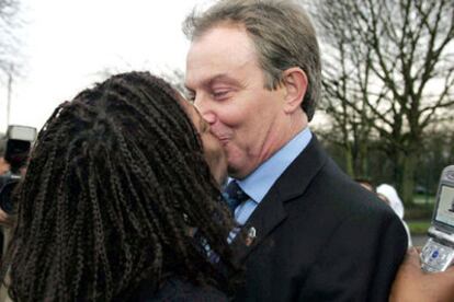 Una admiradora besa en los labios a Tony Blair durante su visita a Manchester.