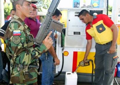 Un soldado vigila una gasolinera que no secundó la huelga general  contra el presidente Hugo Chávez.