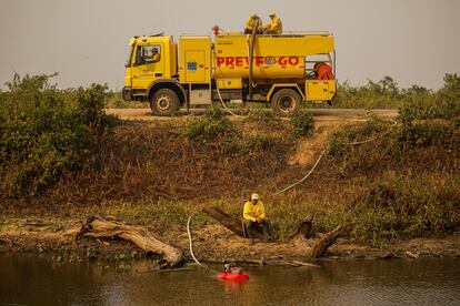 Bomberos recogen agua para intentar apagar los incendios, el 17 de noviembre en Proto Jofre.