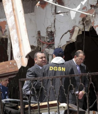 El rey de Marruecos, Mohamed VI, conversa con un agente de policía entre las ruinas del café Argana, donde un atentado acabó con la vida de 16 personas el pasado jueves.