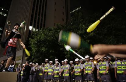 Un activista hace malabares ante un cordón policial, como protesta por el dinero gastado en los preparativos de la Copa del Mundo de fútbol en Sao Paulo, Brasil